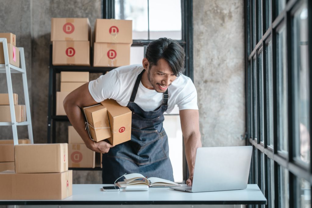 Smiling business owner with packaging in background