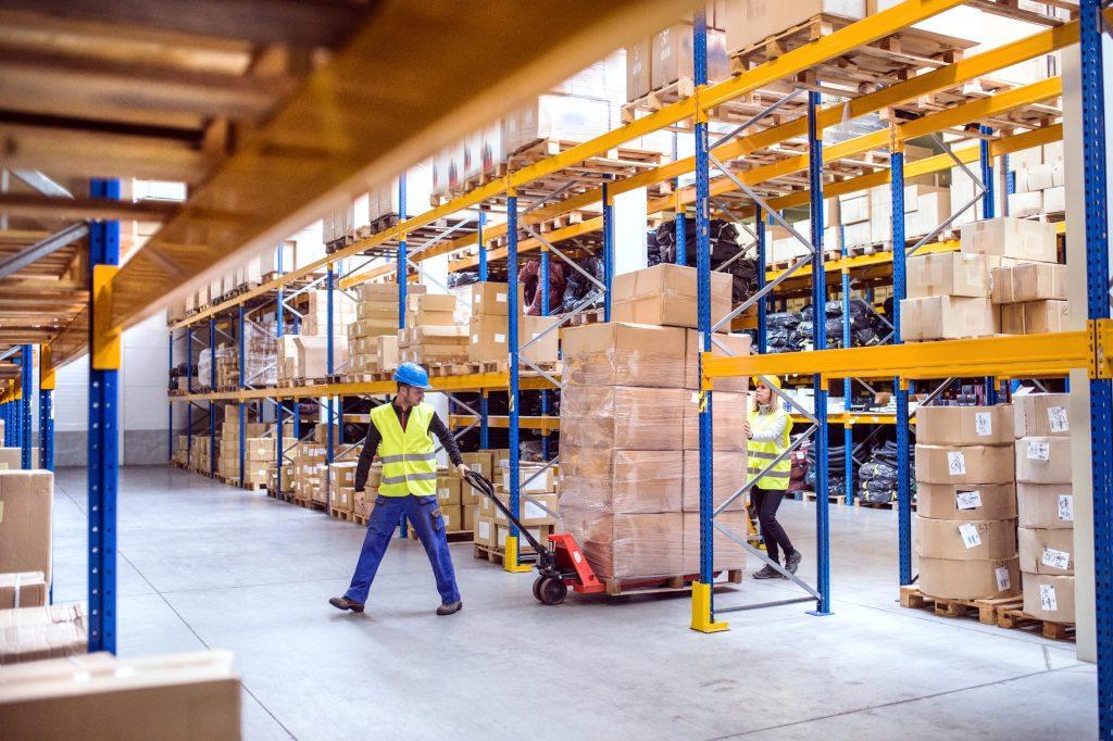 Warehouse workers moving a pallet of boxes at a distribution center